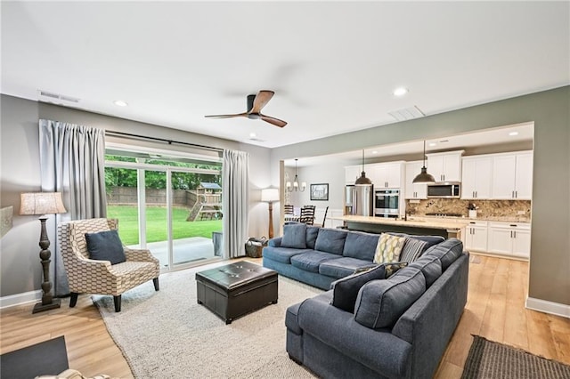 215 Dragonfly Way, Winder, GA 30680 - living area featuring light wood finished floors, ceiling fan, a chandelier, recessed lighting, and baseboards