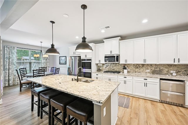 215 Dragonfly Way, Winder, GA 30680 - kitchen featuring appliances with stainless steel finishes, a sink, decorative backsplash, recessed lighting, and light wood finished floors