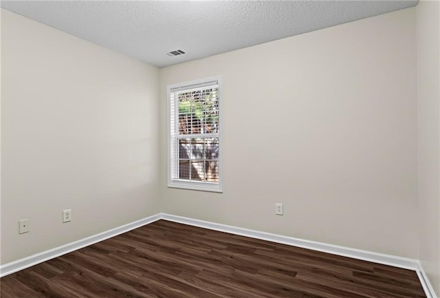 empty room with wood-type flooring and a textured ceiling