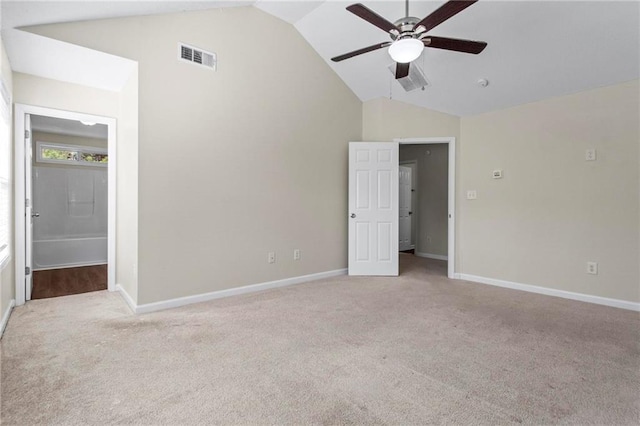 unfurnished bedroom with ceiling fan, connected bathroom, light carpet, and high vaulted ceiling