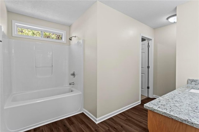 bathroom with washtub / shower combination, wood-type flooring, and vanity