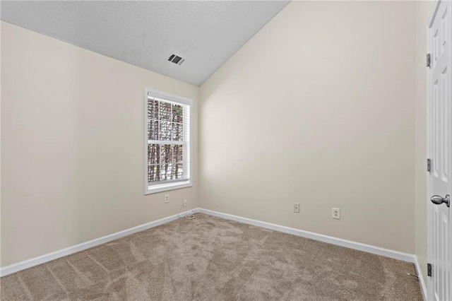 carpeted spare room featuring lofted ceiling and a textured ceiling