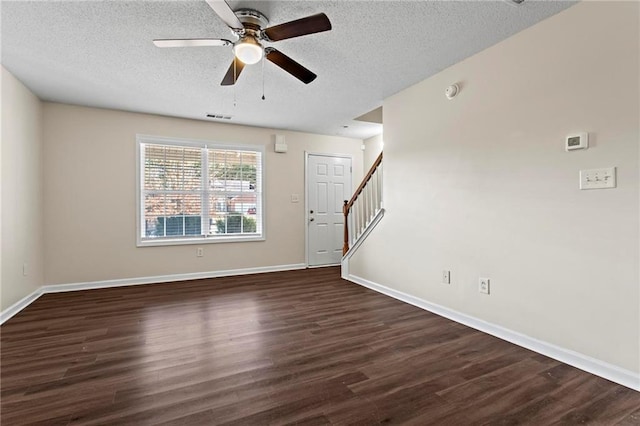 unfurnished living room featuring ceiling fan, dark wood-type flooring, and a textured ceiling