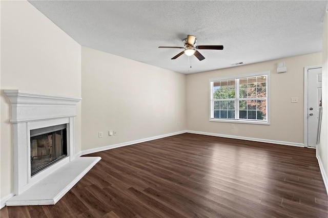 unfurnished living room featuring ceiling fan, a textured ceiling, and dark hardwood / wood-style flooring