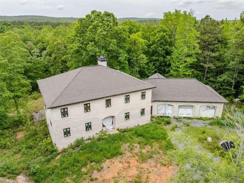 birds eye view of property featuring a wooded view