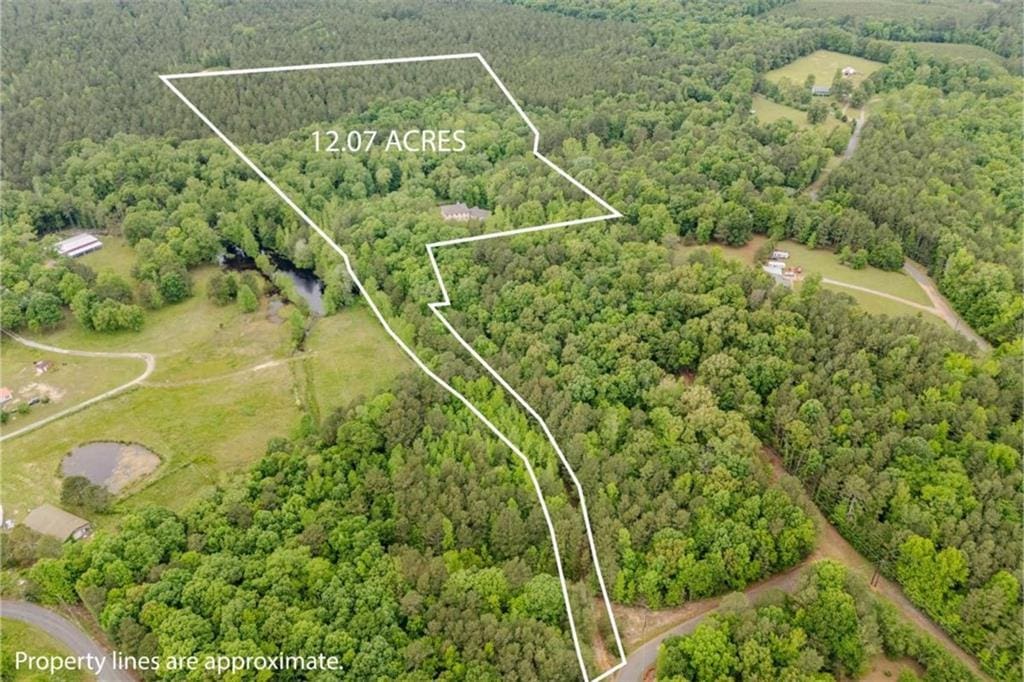 drone / aerial view featuring a wooded view