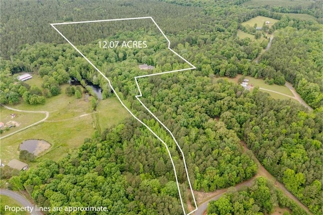 drone / aerial view featuring a wooded view