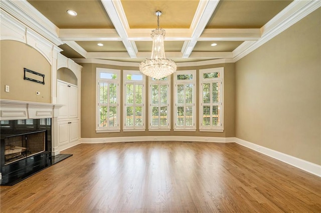 unfurnished living room with baseboards, a chandelier, wood finished floors, and beamed ceiling