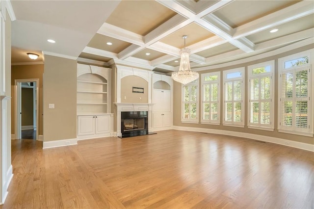 unfurnished living room featuring coffered ceiling, a high end fireplace, baseboards, light wood finished floors, and an inviting chandelier