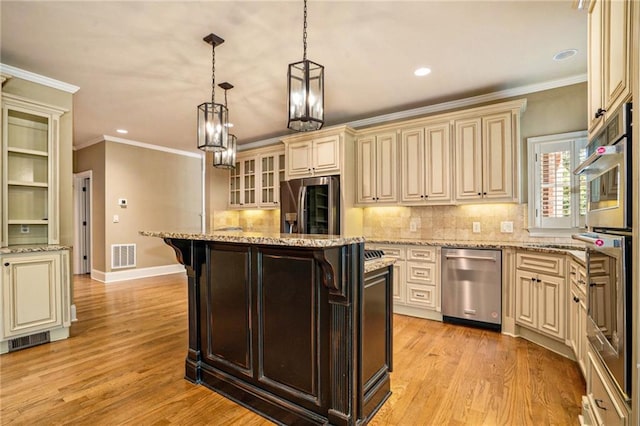 kitchen featuring visible vents, light wood-style flooring, appliances with stainless steel finishes, cream cabinets, and crown molding