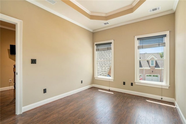 unfurnished room with dark wood-style floors, a raised ceiling, visible vents, and crown molding