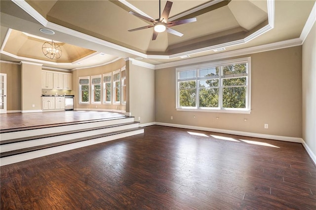 unfurnished living room featuring baseboards, a tray ceiling, wood finished floors, and ornamental molding