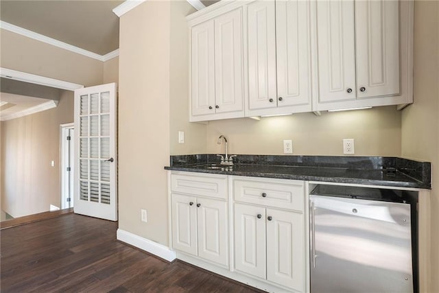 kitchen featuring ornamental molding, dark wood-style flooring, a sink, and white cabinetry