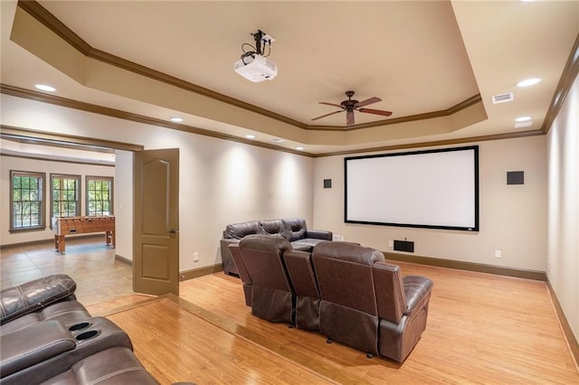 home theater featuring baseboards, a raised ceiling, ceiling fan, light wood-type flooring, and recessed lighting