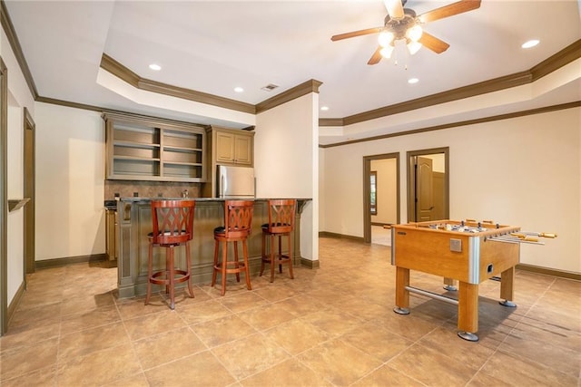 rec room with indoor wet bar, a raised ceiling, visible vents, and baseboards