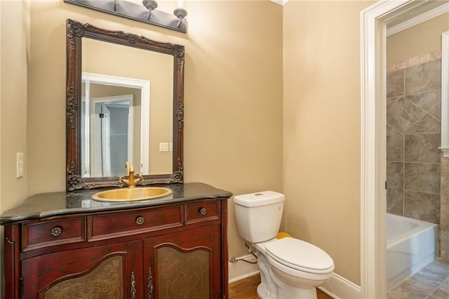 bathroom with toilet, baseboards, and vanity