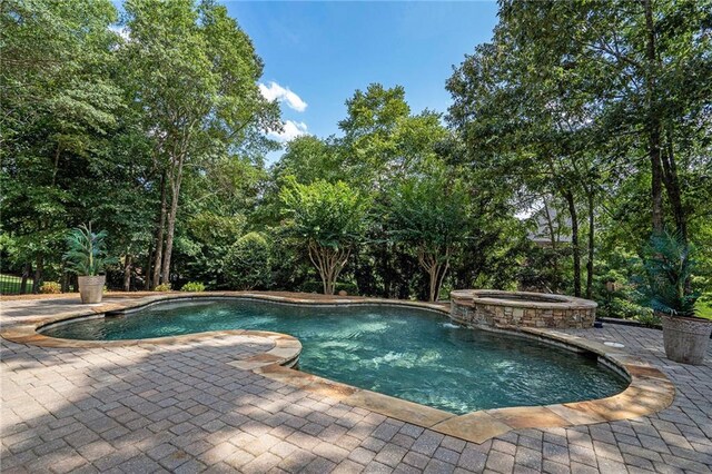 view of swimming pool featuring a pool with connected hot tub and a patio area