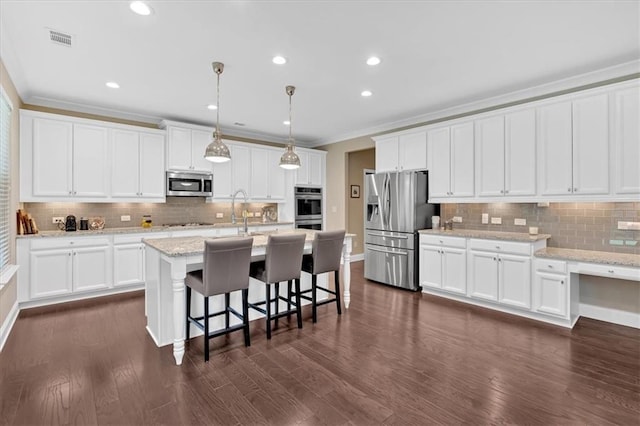 12 Pine St, Roswell, GA 30075 - kitchen with stainless steel appliances, crown molding, tasteful backsplash, baseboards, and a kitchen bar