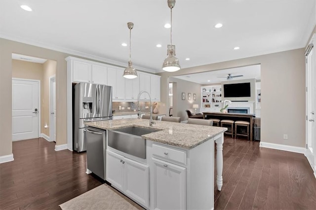 12 Pine St, Roswell, GA 30075 - kitchen with stainless steel appliances, a sink, ceiling fan, baseboards, and an island with sink