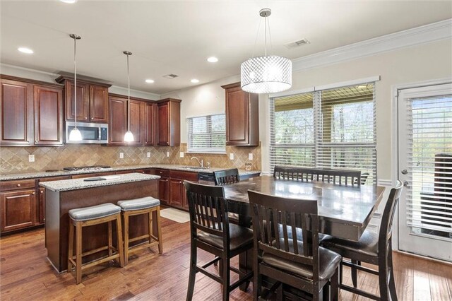 kitchen featuring a wealth of natural light, a center island, dark wood-type flooring, and appliances with stainless steel finishes