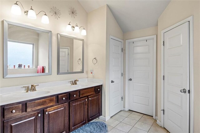 bathroom featuring tile patterned flooring, vanity, and vaulted ceiling