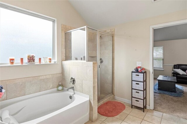 bathroom with tile patterned floors, separate shower and tub, and lofted ceiling