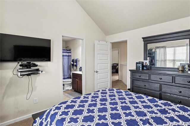 bedroom with carpet flooring, ensuite bathroom, and high vaulted ceiling