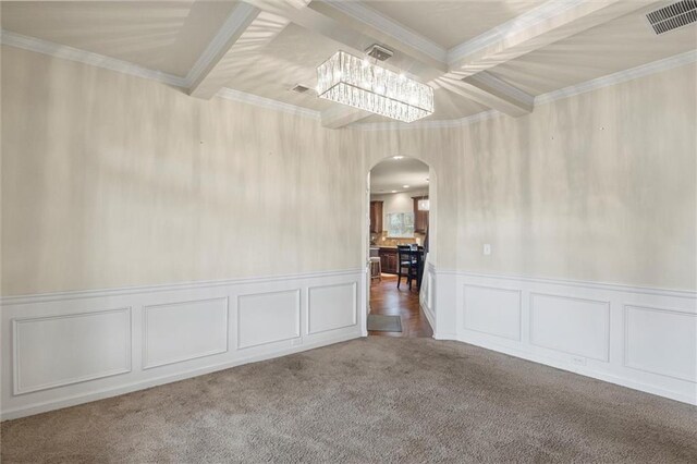 spare room featuring crown molding, carpet, and a notable chandelier