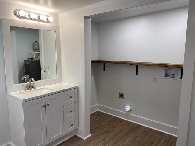 bathroom featuring hardwood / wood-style floors, vanity, and electric water heater