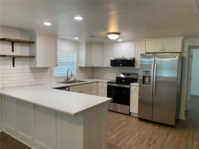 kitchen featuring white cabinets, sink, appliances with stainless steel finishes, and light hardwood / wood-style flooring