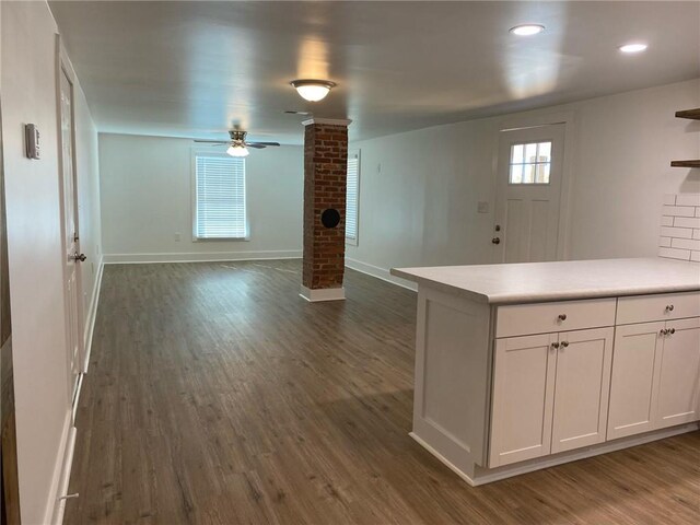 kitchen featuring white cabinets, ornate columns, ceiling fan, and dark wood-type flooring