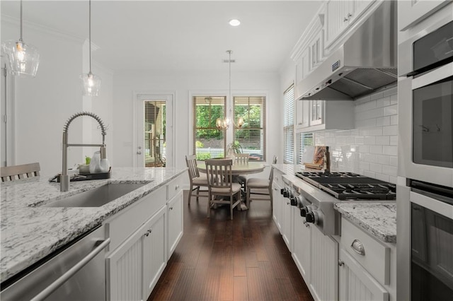 kitchen with backsplash, a sink, under cabinet range hood, stainless steel appliances, and recessed lighting