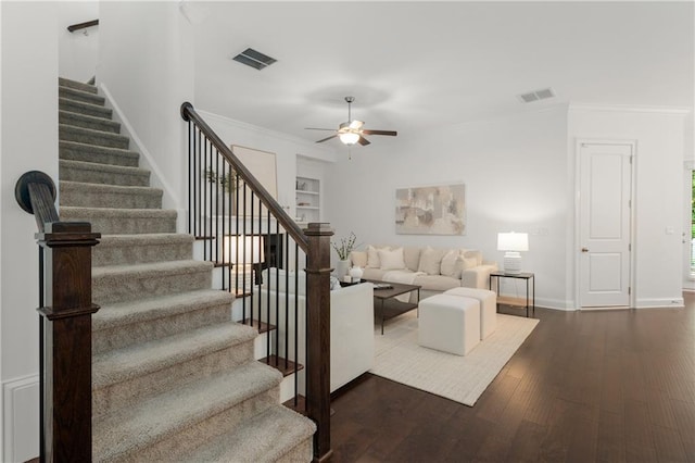 living area featuring visible vents, stairs, and crown molding