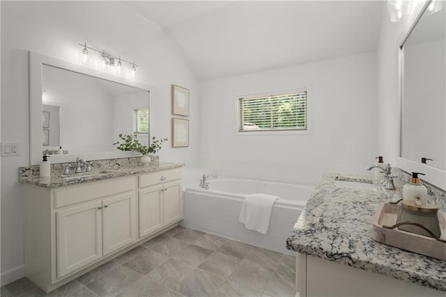 full bathroom with a garden tub, a sink, two vanities, and vaulted ceiling
