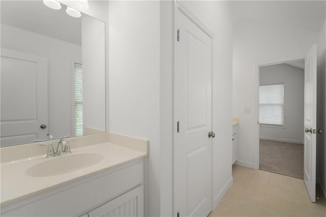bathroom with vanity, tile patterned flooring, and baseboards