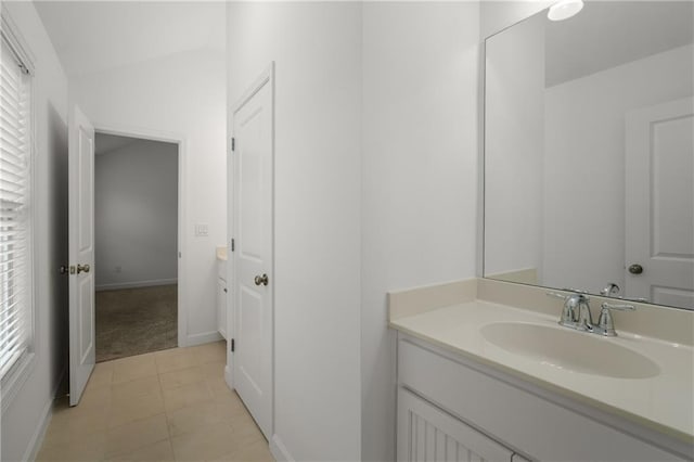 bathroom with plenty of natural light, baseboards, tile patterned floors, and vanity