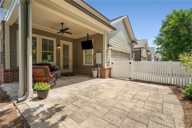 view of patio with fence, a ceiling fan, and a garage