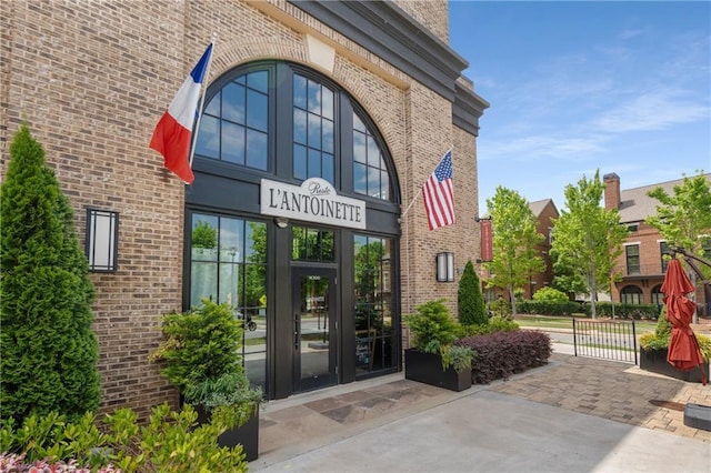 view of exterior entry featuring brick siding and french doors