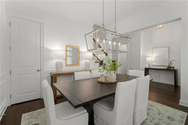 dining space with an inviting chandelier, ornamental molding, stairs, and wood finished floors