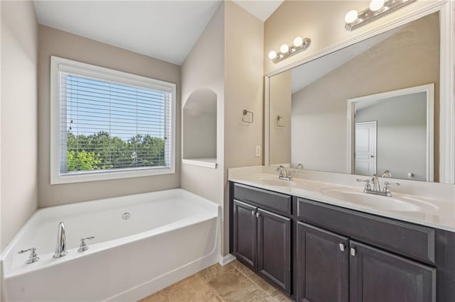 bathroom featuring double vanity, a bath, and a sink