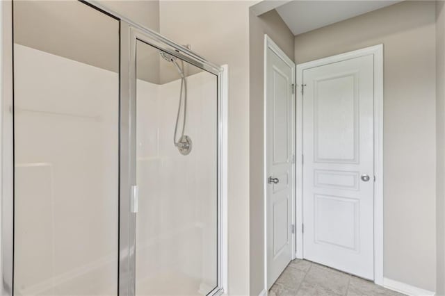 bathroom featuring baseboards, a stall shower, and tile patterned flooring