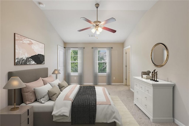 bedroom featuring visible vents, baseboards, lofted ceiling, and light carpet