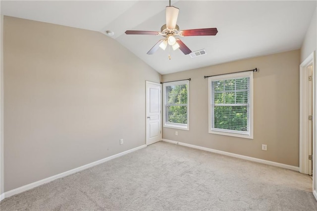 carpeted empty room featuring vaulted ceiling, visible vents, baseboards, and a ceiling fan