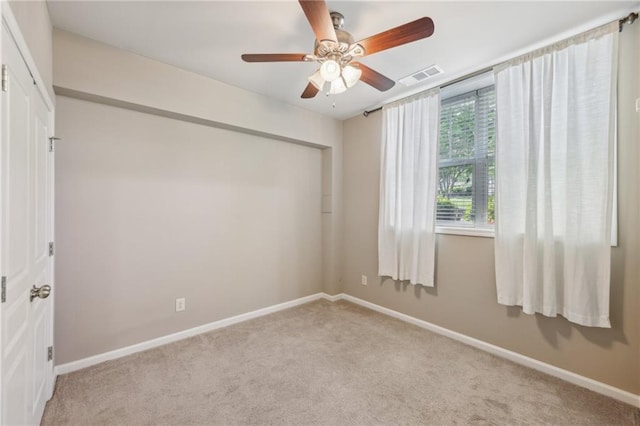 unfurnished room with carpet, baseboards, and a ceiling fan