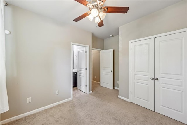 unfurnished bedroom with a closet, baseboards, ceiling fan, connected bathroom, and carpet floors