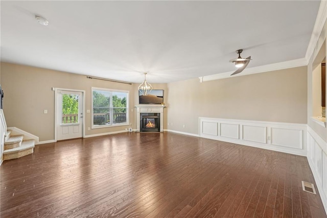 unfurnished living room with visible vents, stairway, hardwood / wood-style floors, and a glass covered fireplace