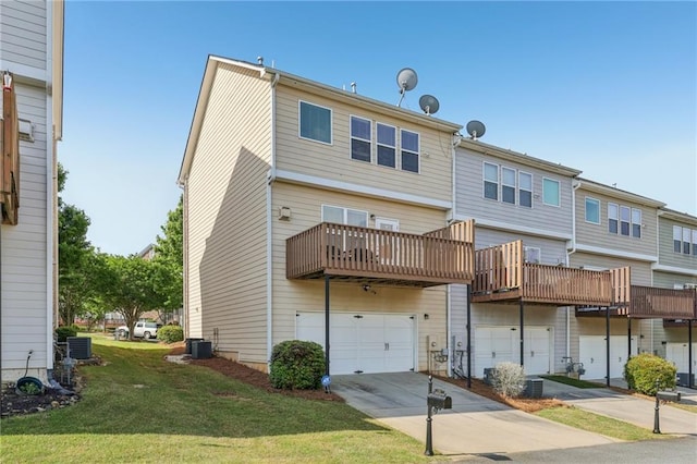 back of house featuring a lawn, driveway, central air condition unit, and an attached garage