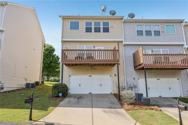 back of house with a balcony, concrete driveway, a garage, a lawn, and central AC unit