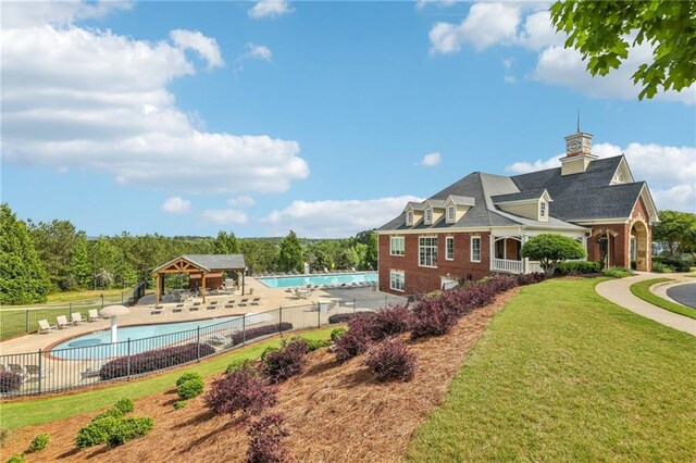exterior space with a lawn, a gazebo, and fence