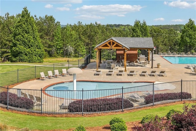 community pool with a gazebo, a patio area, and fence